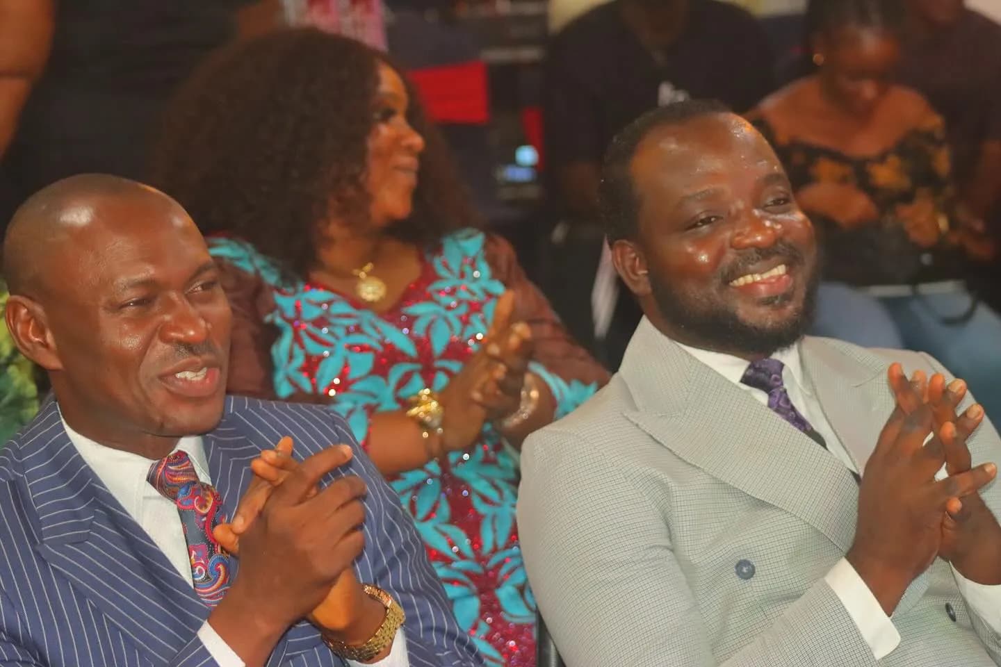 Members and leaders of Worldlight International Church clapping together in celebration